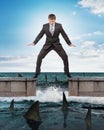 Businessman standing above sharks Royalty Free Stock Photo