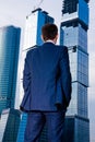 Businessman standing back against skyscraper