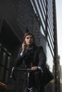 Businessman standing by bicycle in street talking on mobile phone