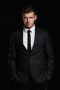 Businessman standing on black background. handsome young Man in suit