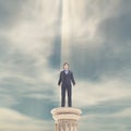 Businessman standing on a column