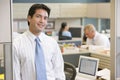 Businessman standing in cubicle smiling