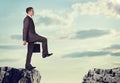 Businessman standing on the edge of rock gap Royalty Free Stock Photo