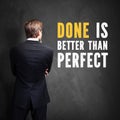 Businessman standing in front of chalkboard with the message `Done is better than perfect` Royalty Free Stock Photo