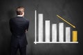 Businessman standing in front of a diagram with decreasing bars Royalty Free Stock Photo