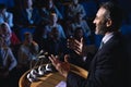 Businessman standing and giving presentation in the auditorium