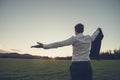 Businessman standing in green meadow looking towards the sunset Royalty Free Stock Photo