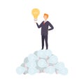 Businessman Standing on Heap of Electric Light Bulbs and Holding Glowing Light Bulb, Brainstorming, Innovation