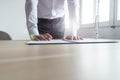 Businessman standing at his office desk leaning to sign a contra Royalty Free Stock Photo