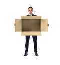 Businessman standing and holding big open empty light beige cardboard mail box in his hands, isolated on the white