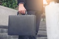 Businessman standing and holding a briefcase in hand working wit Royalty Free Stock Photo