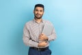 Businessman standing holding closed laptop or folder, looking at camera with positive expression. Royalty Free Stock Photo