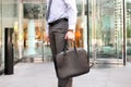 Businessman standing and holding a leather briefcase in his hand. Royalty Free Stock Photo