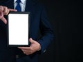 Businessman standing holding white screen tablet on dark background. Advertising concept. Banner sign Royalty Free Stock Photo