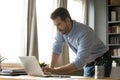 Businessman standing lean over workplace desk working on wireless computer Royalty Free Stock Photo