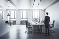 Businessman standing in modern coworking loft interior