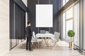 Businessman standing in modern meeting room office interior with empty mock up banner, wooden flooring, table, armchairs, window Royalty Free Stock Photo