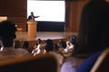 Businessman standing near podium and giving presentation on white projector in the auditorium Royalty Free Stock Photo