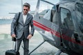 Businessman standing near private helicopter