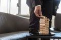 Businessman standing in office building a tower of stacked block