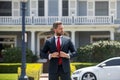 Businessman standing outside a modern house. Real estate concept. Agent ready to sell home. Royalty Free Stock Photo