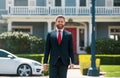 Businessman standing outside a modern house. Real estate concept. Agent ready to sell home. Royalty Free Stock Photo