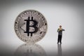 Businessman standing reading business books beside bitcoin. Image use for business concept, miniature people