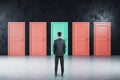 Businessman standing in room and looking on five closed doors Royalty Free Stock Photo