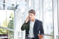 Businessman standing and talking on mobile phone in office Royalty Free Stock Photo