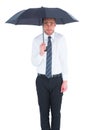Businessman standing under black umbrella Royalty Free Stock Photo