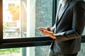 Businessman standing by the window using a tablet.