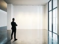 Businessman stands in blank white museum interior with concrete floor. Horizontal