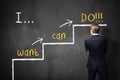 Businessman stands in front of a blackboard with a motivational message