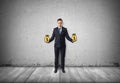 Businessman stands holding pictured bags of money on concrete wall Royalty Free Stock Photo