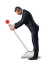 A businessman stands at a large lever with a red round knob and starts to move it. Royalty Free Stock Photo