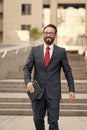 businessman stands at office building with tablet in hand. person dressed in business suit and white shirt do business affairs