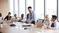 Businessman Stands To Address Meeting Around Board Table Royalty Free Stock Photo