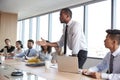 Businessman Stands To Address Meeting Around Board Table Royalty Free Stock Photo