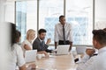 Businessman Stands To Address Meeting Around Board Table Royalty Free Stock Photo