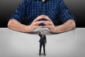 Businessman stands touching his head with hand in front of cropped portrait big man sitting Royalty Free Stock Photo