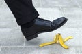 Businessman stepping on banana skin, business work accident danger concept Royalty Free Stock Photo