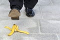 Businessman stepping on banana skin, work accident, copy space Royalty Free Stock Photo