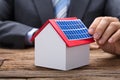 Businessman Sticking Solar Panel On Model Home Royalty Free Stock Photo