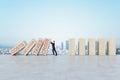 Businessman stopping abstract wooden domino blocks on bright sky background with mock up place. Crisis, recession and challenge