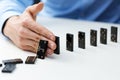 Businessman stopping domino effect - business problem solving co Royalty Free Stock Photo