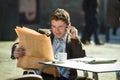 Businessman on street bar having breakfast coffee reading newspaper news talking on mobile phone Royalty Free Stock Photo