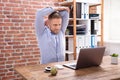 Businessman Stretching His Arms At Work Place