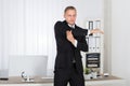 Businessman Stretching In Office