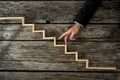 Businessman or student walking his fingers up wooden steps Royalty Free Stock Photo