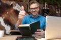 Businessman studying from book while giving a thumbs up Royalty Free Stock Photo